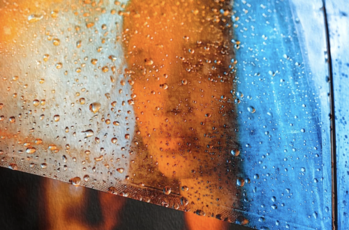 black woman portrait behind glass with blue hair