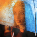 black woman portrait behind glass with blue hair