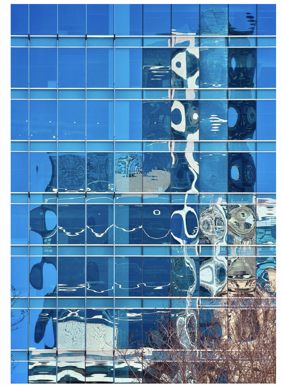 photograph of a tall building with water reflected into the front