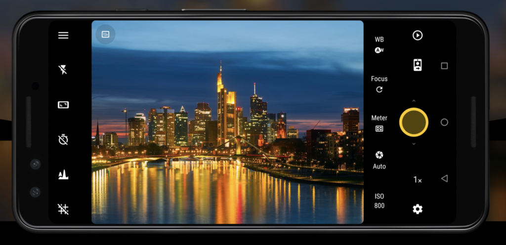Screenshot of the Camera FV-5 Android camera app showing its DSLR-style manual controls, including ISO, white balance, focus, exposure metering and shooting settings, with a long-exposure night cityscape displayed in the live viewfinder.