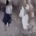 Abstract, painterly image of two human figures standing side by side against a muted grey background. The figure on the left wears a dark navy garment with a bright white apron-like shape, while the figure on the right appears in a loose white dress with softly textured brown and pink tones. Both figures are heavily distorted with swirling, fluid brushstrokes that obscure facial features and dissolve their forms into the surrounding space, creating a dreamlike, ethereal atmosphere suggestive of memory, identity and impermanence.