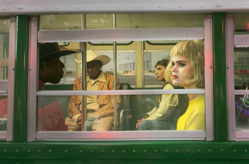 Alex Prager photograph of passengers in colourful retro clothing seen through the window of a bus.