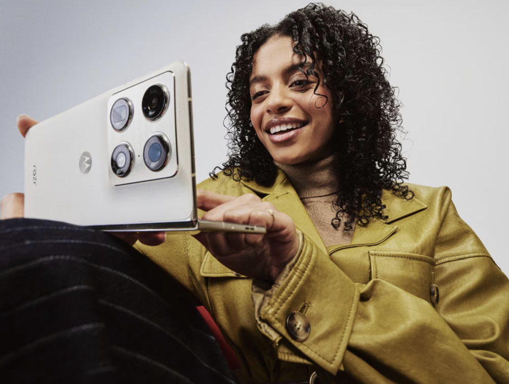 Woman using the Motorola Razr Fold while the foldable smartphone is partially open in her hands.