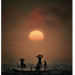 Silhouetted figures stand on a small boat beneath an enormous glowing orange sun at sunset. The dark, shimmering water and hazy burnt-orange sky create a dramatic contrast, while two figures hold their hands to their heads as they look towards the horizon.